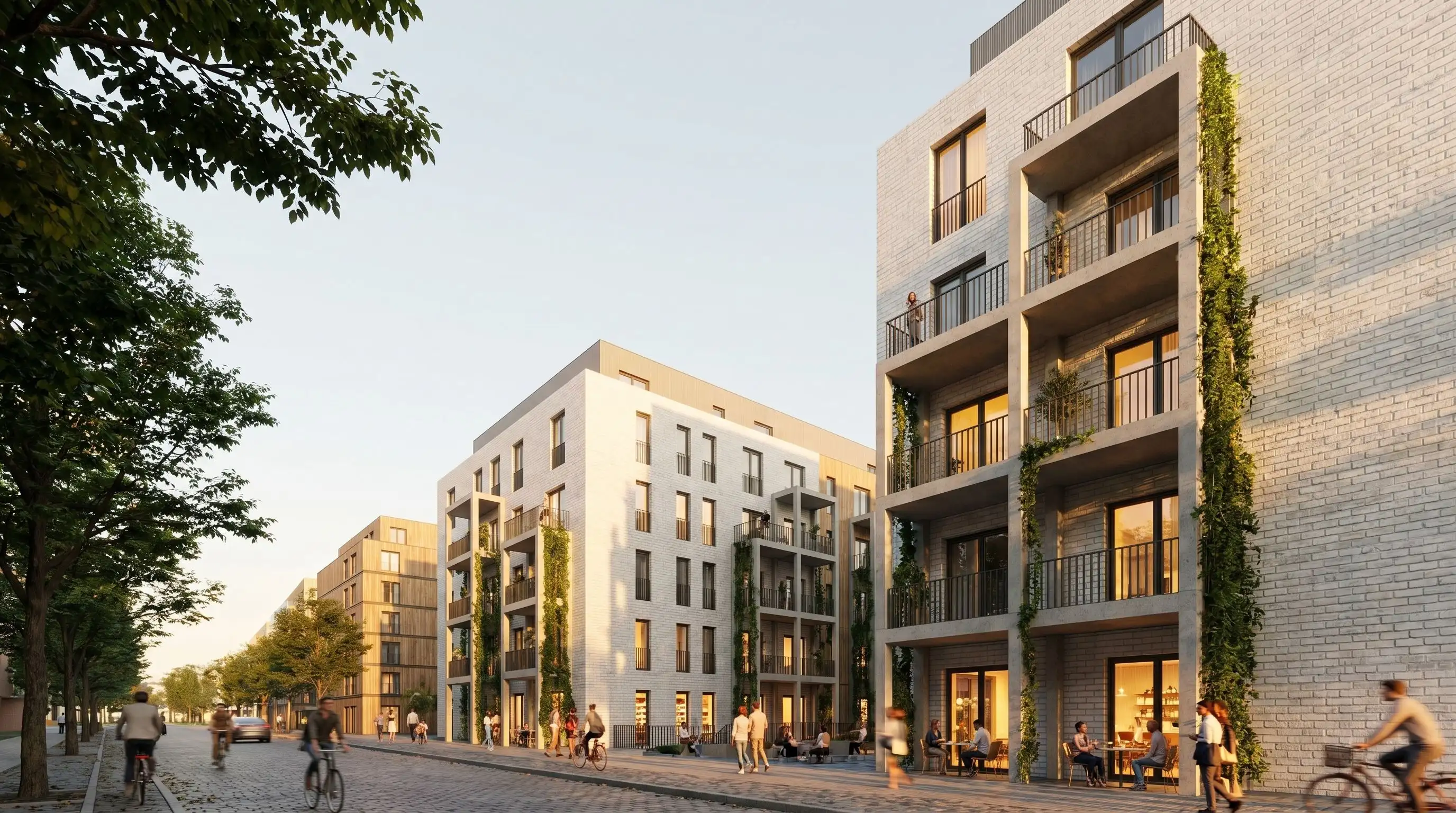 Straßenperspektive mit Wohnfassaden, Balkonen, Erdgeschossnutzung und Bäumen.